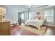 A serene main bedroom boasts hardwood floors, neutral decor, and ample natural light for a calming retreat at 215 Strolling Way, Durham, NC 27707