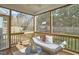 Cozy screened-in porch with a daybed and a view of the backyard play area at 215 Strolling Way, Durham, NC 27707