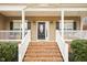 Inviting front porch featuring a brick staircase, porch swing, and a decorative front door at 22 Hill Row Ln, Clayton, NC 27527