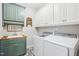 Bright laundry room featuring sleek appliances, custom cabinetry, and stylish tile flooring at 22 Hill Row Ln, Clayton, NC 27527