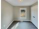 Bright bedroom with neutral walls, modern gray floors, a window view, and a double-door closet at 2412 Little John Rd, Raleigh, NC 27610