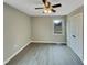 Bedroom featuring light walls, modern gray floors, a ceiling fan, a window view, and a closet at 2412 Little John Rd, Raleigh, NC 27610
