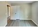A well-lit bedroom with light gray walls and grey laminate flooring, has a spacious closet for ample storage at 2412 Little John Rd, Raleigh, NC 27610