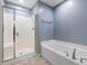 Clean bathroom featuring a shower and a soaking tub with blue walls at 2459 Memory Ridge Dr, Raleigh, NC 27606