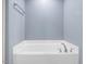 Close-up of bathroom tub with tile floors, blue walls and towel bar at 2459 Memory Ridge Dr, Raleigh, NC 27606