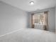 Comfortable bedroom with neutral carpet, a ceiling fan, and a large window overlooking the front yard at 2459 Memory Ridge Dr, Raleigh, NC 27606