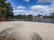 Community beach with volleyball net, sand, lake and community views under a blue sky at 2459 Memory Ridge Dr, Raleigh, NC 27606
