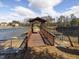 Wooden bridge and dock extending over the water, enhancing the community's access to the lake for leisure and recreation at 2459 Memory Ridge Dr, Raleigh, NC 27606