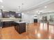 Open concept living space with kitchen island, dark cabinetry, hardwood floors and fireplace at 2459 Memory Ridge Dr, Raleigh, NC 27606