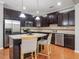 Well-lit kitchen with stainless appliances, tile backsplash, granite countertops, and seating at the island at 2459 Memory Ridge Dr, Raleigh, NC 27606