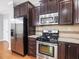 Kitchen featuring stainless steel appliances, dark cabinets, and granite countertops at 2459 Memory Ridge Dr, Raleigh, NC 27606