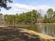 Beautiful lake view featuring a pier, lush trees, and a peaceful waterfront setting at 2459 Memory Ridge Dr, Raleigh, NC 27606