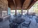 Outdoor patio offering tables and chairs with ceiling fans overhead, and a beautiful stone fireplace at 2459 Memory Ridge Dr, Raleigh, NC 27606