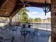 Outdoor patio featuring tables, chairs and stone pillars with serene lake views and convenient grilling stations at 2459 Memory Ridge Dr, Raleigh, NC 27606