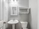 Neat powder room with a pedestal sink, ample lighting, and a convenient storage shelf at 2459 Memory Ridge Dr, Raleigh, NC 27606