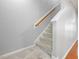 Carpeted staircase featuring a wooden handrail and white trim leading to the upper level at 2459 Memory Ridge Dr, Raleigh, NC 27606
