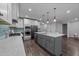 Open kitchen boasts stainless steel appliances, gray lower cabinets, and a blue backsplash at 2500 Plowridge Rd, Fuquay Varina, NC 27526