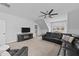 Open living room featuring carpeted floors, a ceiling fan, and a black leather couch at 2500 Plowridge Rd, Fuquay Varina, NC 27526