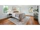 Well-lit bedroom with neutral decor, hardwood floors, area rug, and multiple windows for natural light at 303 Granville Rd, Chapel Hill, NC 27514
