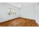 Bright bedroom featuring hardwood floors, a ceiling fan, and windows with natural light at 303 Granville Rd, Chapel Hill, NC 27514