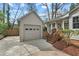Exterior shot showcasing the detached garage, convenient access, tidy landscaping, and neutral siding at 303 Granville Rd, Chapel Hill, NC 27514