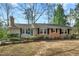 Inviting single-story brick home with black shutters and a well-maintained yard, creating a welcoming curb appeal at 303 Granville Rd, Chapel Hill, NC 27514