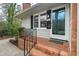 Close-up of the front porch with brick steps, black railings, and a view of the front door at 303 Granville Rd, Chapel Hill, NC 27514