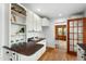 Kitchen features white cabinetry, granite countertops, hardwood floors, and shelves with decor at 303 Granville Rd, Chapel Hill, NC 27514