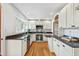 Bright kitchen with white cabinetry, granite countertops, stainless steel appliances, and hardwood floors at 303 Granville Rd, Chapel Hill, NC 27514