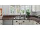 Close up of the kitchen sink with white cabinets, granite countertops, and a window overlooking the yard at 303 Granville Rd, Chapel Hill, NC 27514