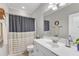 A bathroom featuring a single sink vanity with a framed mirror and striped shower curtain at 330 Bridgeport Cir, Clayton, NC 27527