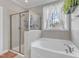 Bright bathroom featuring a soaking tub next to the shower with natural light at 330 Bridgeport Cir, Clayton, NC 27527