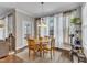 A sunlit dining area with hardwood floors, sheer curtains, and an ornamental light fixture at 330 Bridgeport Cir, Clayton, NC 27527