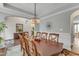 Dining room boasting hardwood floors, a stylish chandelier, and views into other living spaces at 330 Bridgeport Cir, Clayton, NC 27527