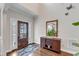 Inviting foyer with a decorative cabinet, a stylish mirror, hardwood floors, and natural light streaming through the front door at 330 Bridgeport Cir, Clayton, NC 27527