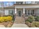 Inviting front porch with stone steps, elegant columns, stylish railing, and a charming wreath on the front door at 330 Bridgeport Cir, Clayton, NC 27527