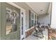 Cozy front porch featuring two rocking chairs, complemented by stylish lighting and stone accents at 330 Bridgeport Cir, Clayton, NC 27527