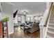 Spacious living room with stairs, fireplace, and a view into the open-concept kitchen at 330 Bridgeport Cir, Clayton, NC 27527