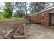 Spacious backyard features a brick patio, garden box, and mature trees at 3429 Dogwood Dr, Raleigh, NC 27604