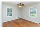 Bright bedroom featuring hardwood floors, a ceiling fan, and natural light from the two windows at 3429 Dogwood Dr, Raleigh, NC 27604