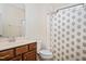 Well-lit bathroom featuring a vanity with wood cabinets and a flower patterned shower curtain at 345 Springtime Fields Ln, Wake Forest, NC 27587