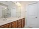 Bathroom with double sinks and a large mirror with bright vanity lights at 345 Springtime Fields Ln, Wake Forest, NC 27587