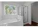 Bathroom featuring a soaking tub with window and a glass enclosed shower at 3624 Singleleaf Ln, Raleigh, NC 27616