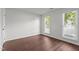Bright bedroom with neutral paint and wood look flooring, illuminated by two windows with blinds at 3624 Singleleaf Ln, Raleigh, NC 27616