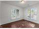 Bedroom with hardwood floors, neutral walls, and abundant natural light from two large windows at 3624 Singleleaf Ln, Raleigh, NC 27616