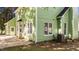 Side/rear exterior view of a two-story home with green siding and a small brick patio at 3624 Singleleaf Ln, Raleigh, NC 27616