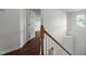 Upstairs hallway with wood flooring, wood and white railing and natural light at 3624 Singleleaf Ln, Raleigh, NC 27616