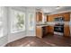 Bright kitchen with stainless steel appliances, wood cabinets, and a charming breakfast nook by the windows at 3624 Singleleaf Ln, Raleigh, NC 27616