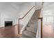 View of the foyer with stairs and hardwood floors, with a view of a fireplace in the living room at 3624 Singleleaf Ln, Raleigh, NC 27616