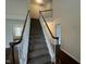 Carpeted stairs with white spindles and dark wood handrail at 3624 Singleleaf Ln, Raleigh, NC 27616